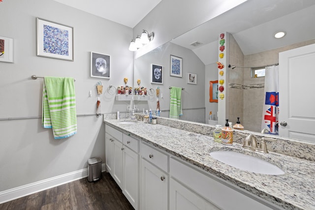 bathroom with vanity, hardwood / wood-style flooring, lofted ceiling, and walk in shower