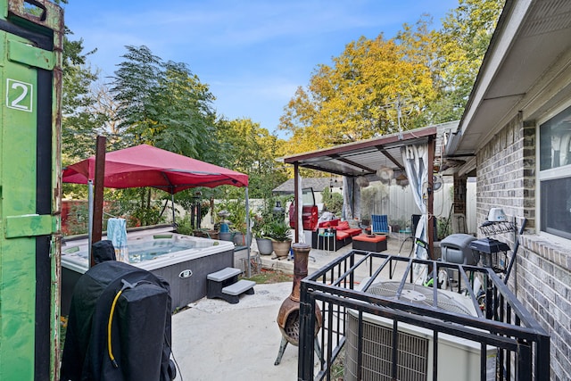 view of patio / terrace with a grill and a hot tub