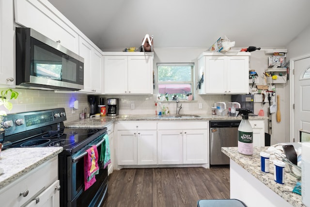 kitchen with appliances with stainless steel finishes, white cabinetry, sink, backsplash, and dark wood-type flooring