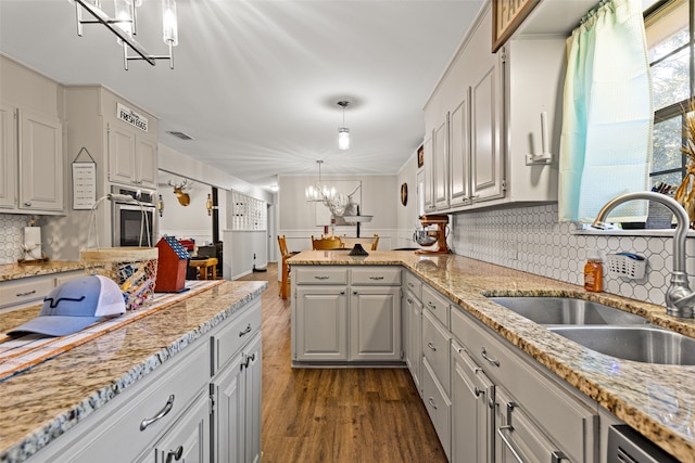 kitchen with sink, white cabinetry, stainless steel appliances, pendant lighting, and dark wood-type flooring