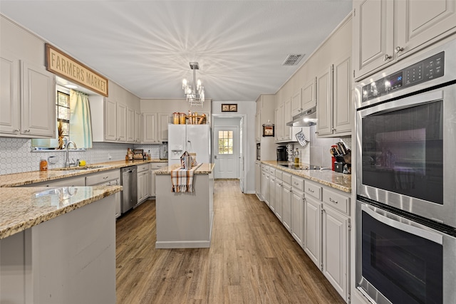 kitchen with a center island, stainless steel appliances, a healthy amount of sunlight, and white cabinetry