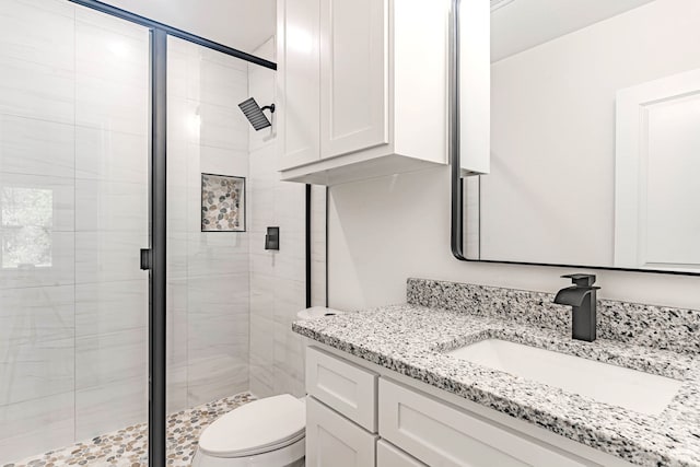 bathroom with an enclosed shower, vanity, and toilet