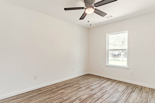 empty room with ceiling fan and light hardwood / wood-style flooring