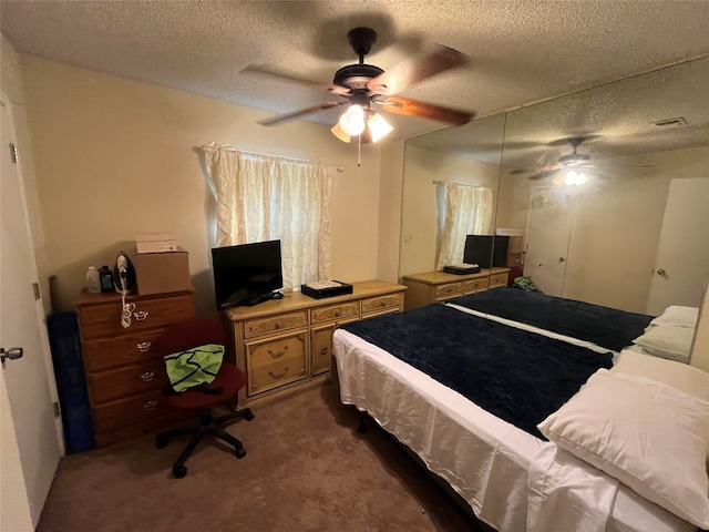 bedroom featuring dark colored carpet, a textured ceiling, and ceiling fan