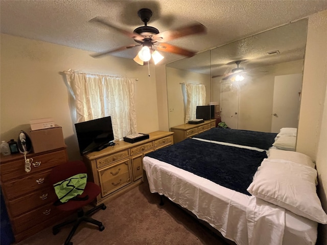 bedroom with dark colored carpet, a textured ceiling, and ceiling fan