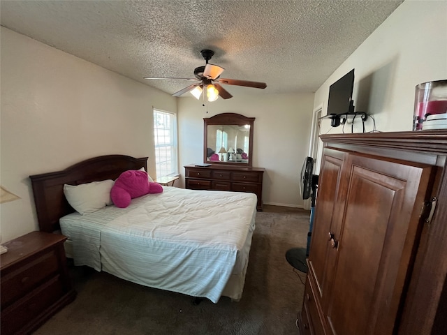 bedroom with ceiling fan, dark carpet, and a textured ceiling