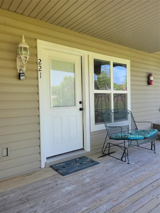 view of exterior entry with a wooden deck