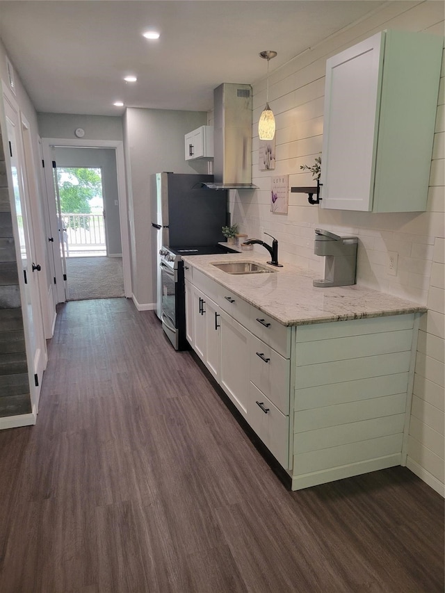 kitchen with sink, decorative light fixtures, wall chimney range hood, white cabinetry, and stainless steel electric range oven