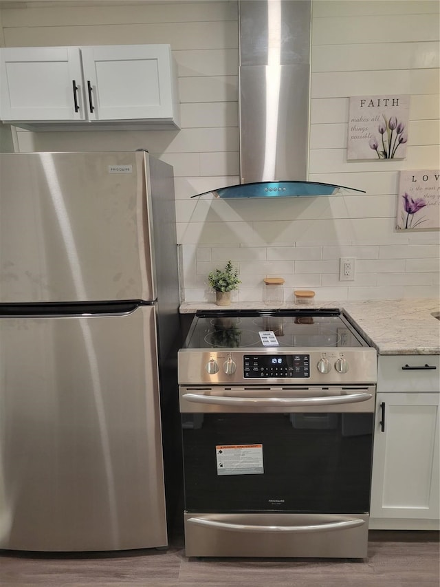 kitchen featuring island range hood, hardwood / wood-style floors, stainless steel appliances, and white cabinets