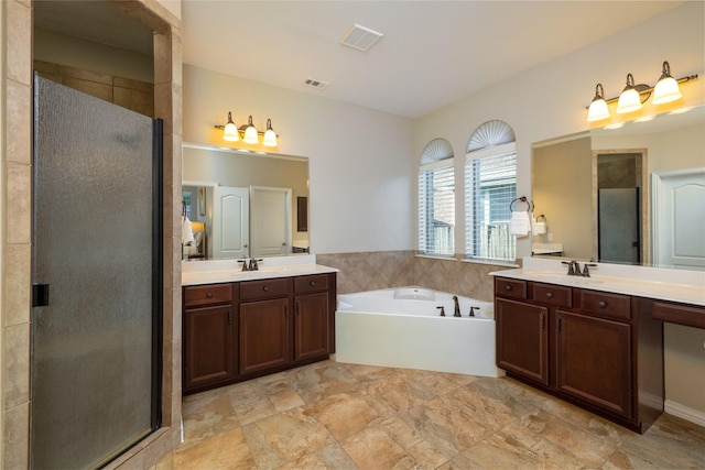 bathroom with vanity and shower with separate bathtub