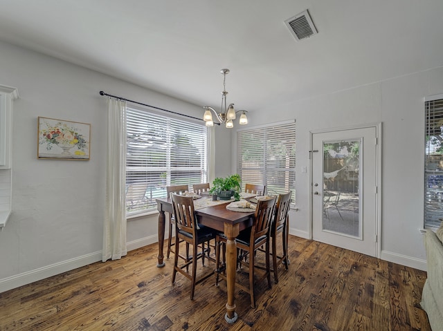 dining area with a notable chandelier, plenty of natural light, and dark hardwood / wood-style floors