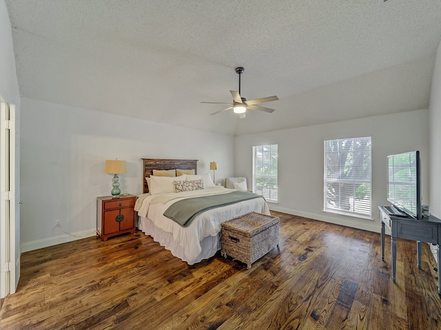 bedroom with ceiling fan, a textured ceiling, lofted ceiling, and dark hardwood / wood-style flooring