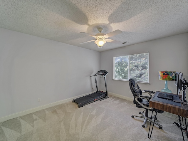 home office featuring light carpet, ceiling fan, and a textured ceiling