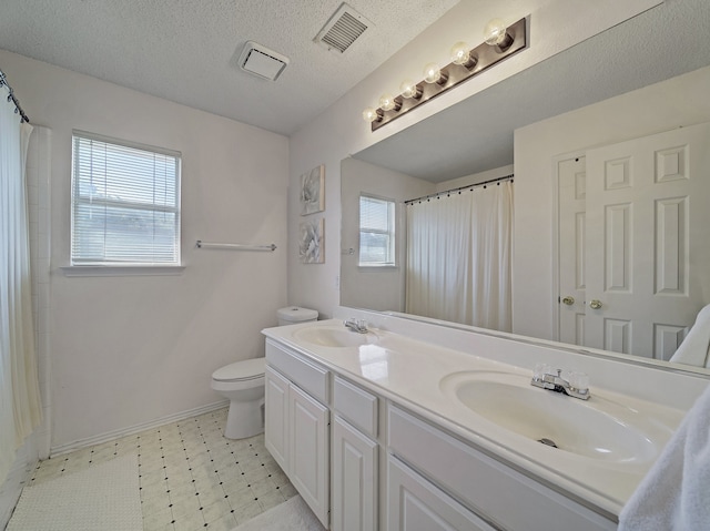 bathroom with a shower with curtain, vanity, toilet, and a textured ceiling