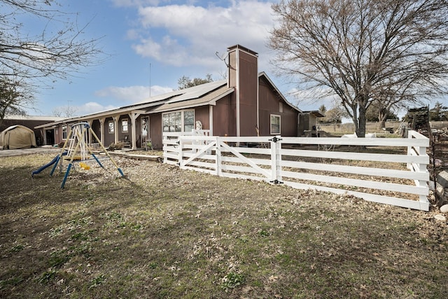11678 S State Highway 121, Trenton, TX 75490 - view of home's exterior with solar panels, fence private yard, a playground, and a chimney