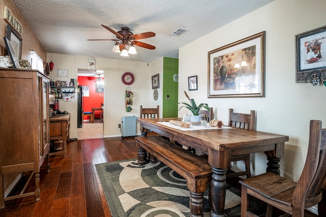 dining room featuring ceiling fan, a textured ceiling, and dark hardwood / wood-style floors