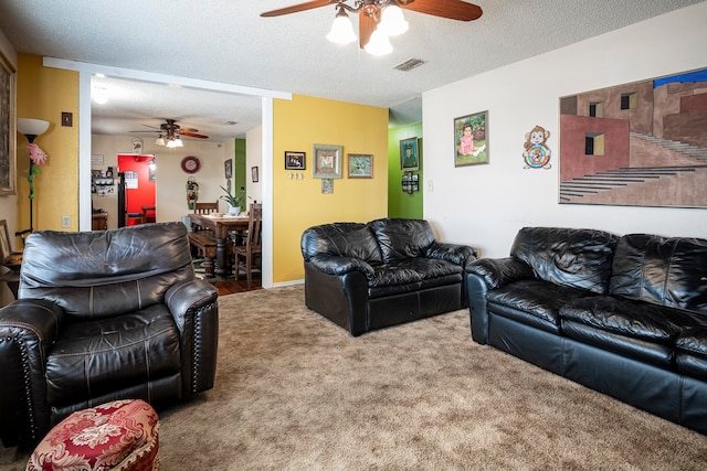 living room with ceiling fan, carpet, and a textured ceiling