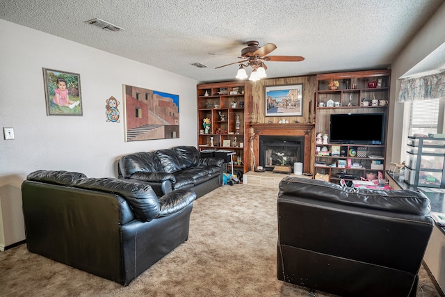 living room featuring carpet flooring, ceiling fan, and a textured ceiling