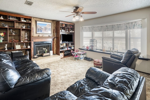11678 S State Highway 121, Trenton, TX 75490 - carpeted living area featuring visible vents, a fireplace with raised hearth, a textured ceiling, and ceiling fan
