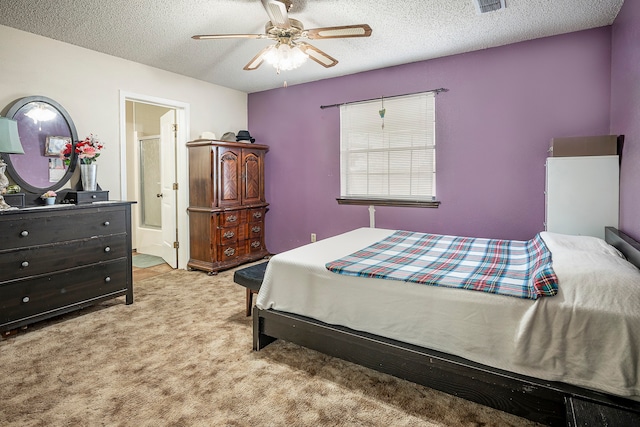 bedroom with ensuite bath, light colored carpet, ceiling fan, and a textured ceiling