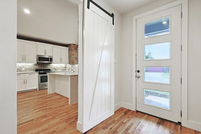 doorway featuring light wood-type flooring and a barn door