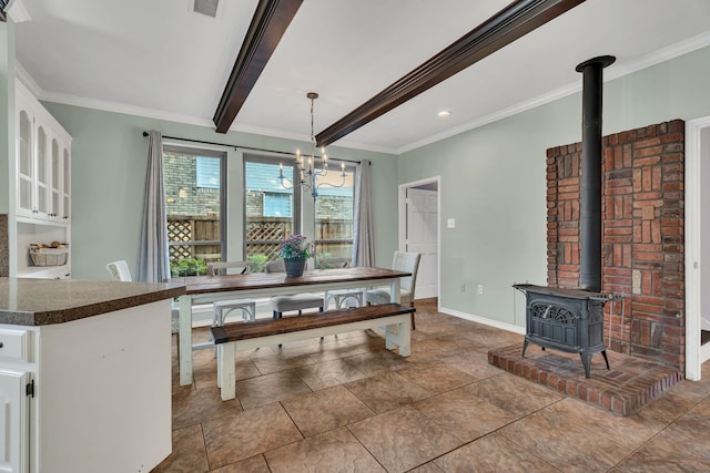 dining area with beam ceiling, a wood stove, crown molding, and a chandelier