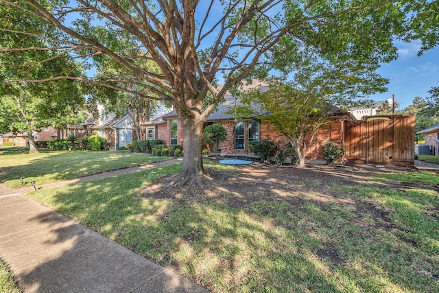 view of property hidden behind natural elements with a front lawn