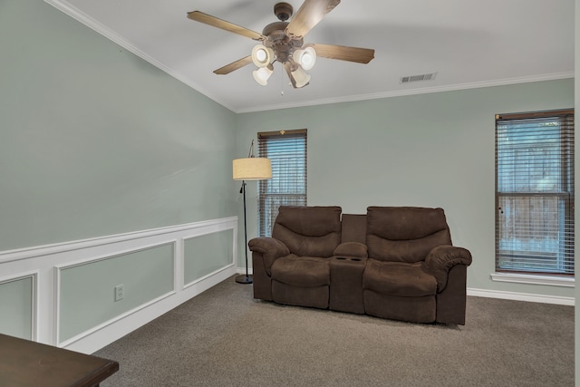 carpeted living room with ceiling fan and ornamental molding