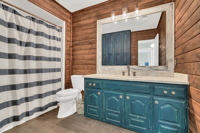 bathroom featuring wooden walls, tile patterned flooring, vanity, and toilet