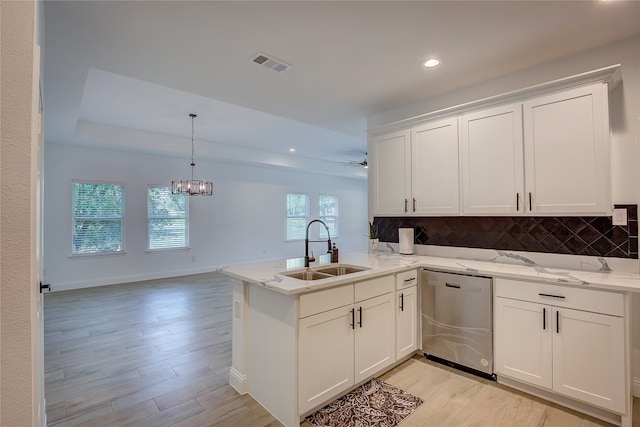 kitchen featuring white cabinets, sink, kitchen peninsula, dishwasher, and light hardwood / wood-style floors