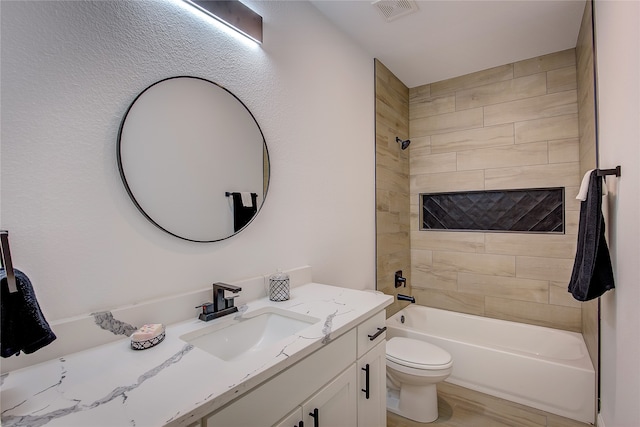 full bathroom with vanity, toilet, and tiled shower / bath combo