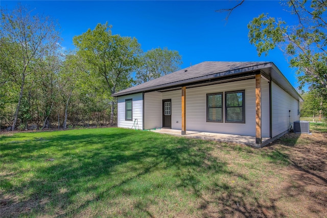 back of property featuring cooling unit and a yard