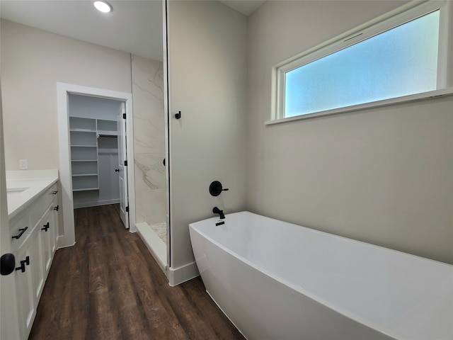 bathroom featuring vanity, hardwood / wood-style floors, and plus walk in shower