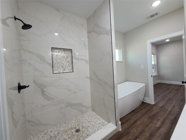 bathroom with hardwood / wood-style flooring and independent shower and bath