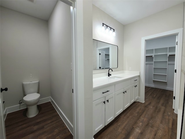 bathroom featuring toilet, vanity, and wood-type flooring