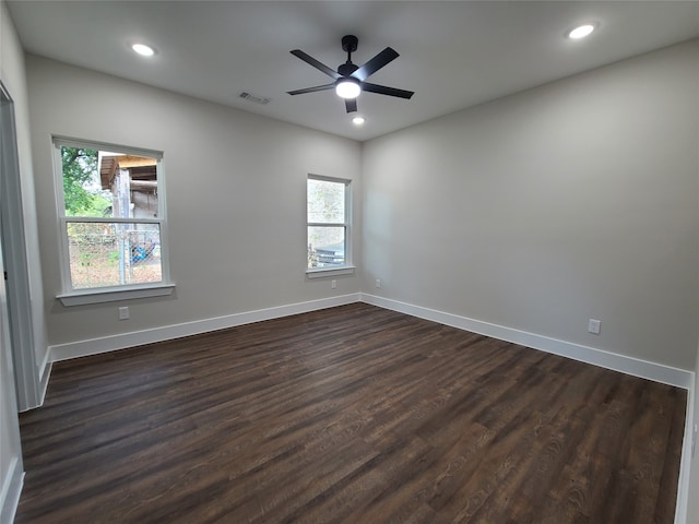 unfurnished room featuring a wealth of natural light, ceiling fan, and dark hardwood / wood-style flooring