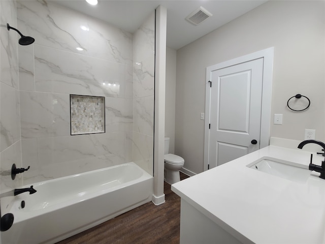 full bathroom with vanity, toilet, wood-type flooring, and tiled shower / bath