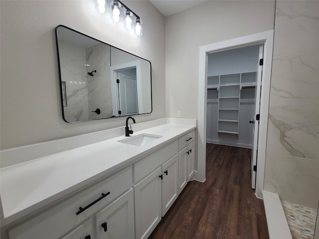 bathroom featuring a tile shower, hardwood / wood-style flooring, and vanity