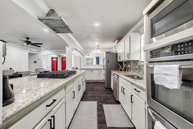 kitchen with dark hardwood / wood-style floors, tasteful backsplash, sink, white cabinetry, and appliances with stainless steel finishes