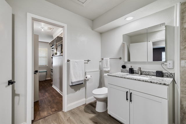 bathroom with wood-type flooring, vanity, and toilet