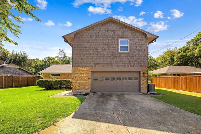 view of front facade featuring a front lawn, central AC unit, and a garage