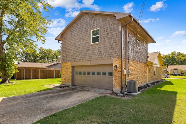 view of side of home with a garage, a yard, and central air condition unit