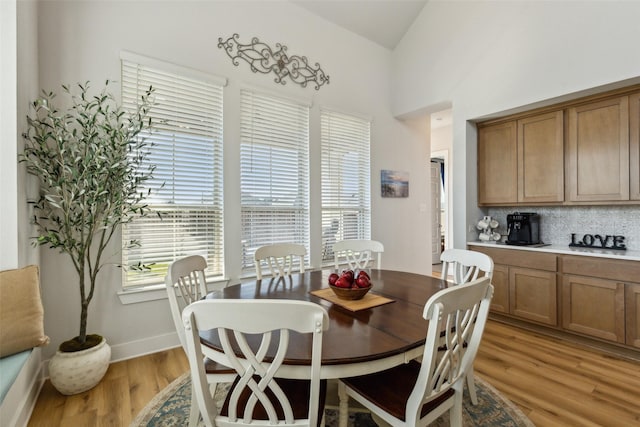 dining space with baseboards and light wood-style floors