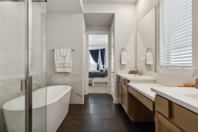 ensuite bathroom featuring tile walls, a soaking tub, an enclosed shower, ensuite bathroom, and vanity