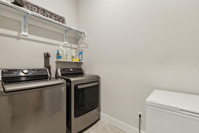 clothes washing area with laundry area, baseboards, and independent washer and dryer