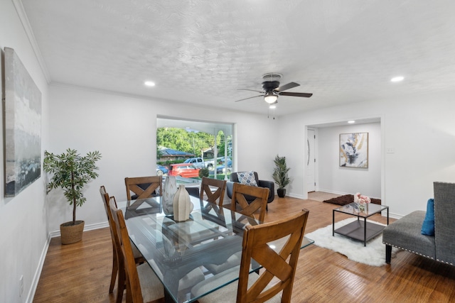 dining room featuring ceiling fan, hardwood / wood-style flooring, crown molding, and a textured ceiling