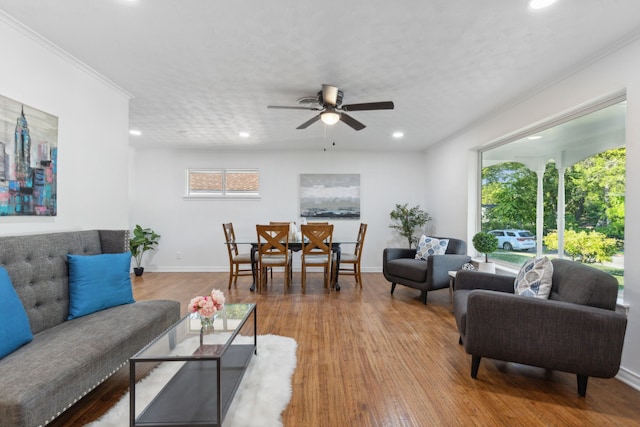 living room featuring ceiling fan, hardwood / wood-style flooring, crown molding, and a textured ceiling