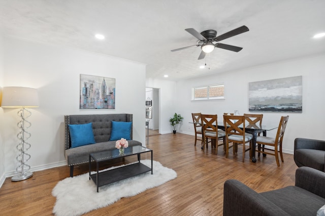 living room featuring crown molding, hardwood / wood-style flooring, and ceiling fan