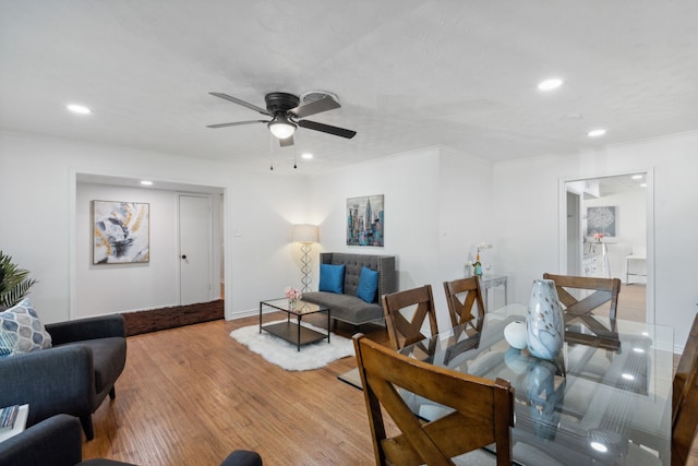 living room featuring ceiling fan, light wood-type flooring, and ornamental molding