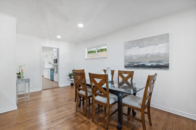 dining room featuring wood-type flooring and crown molding